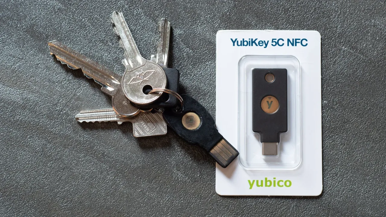 Аппаратные ключи YubiKey рядом с обычными ключами и упаковкой YubiKey 5C NFC.