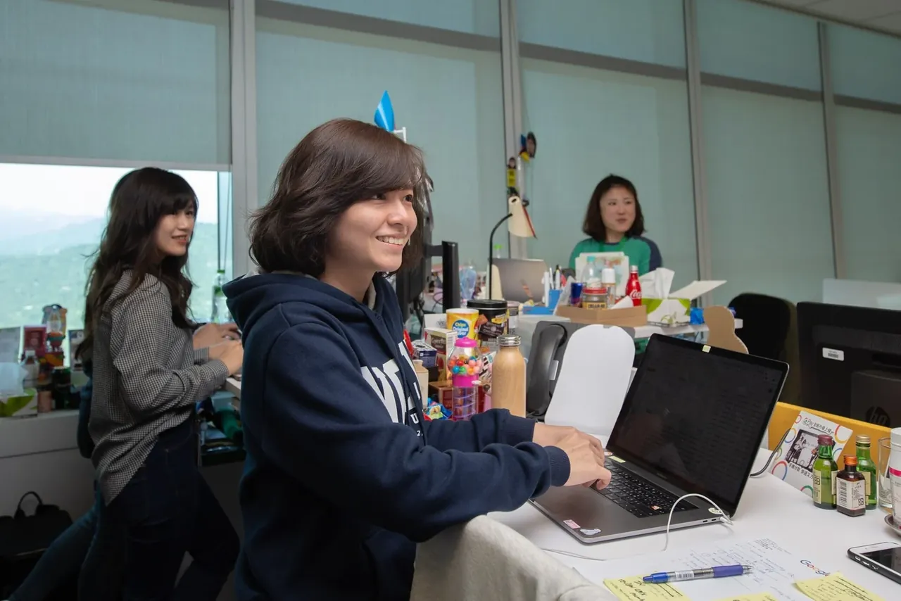 Сотрудницы Google за рабочими столами с ноутбуками в офисе Taipei 101.