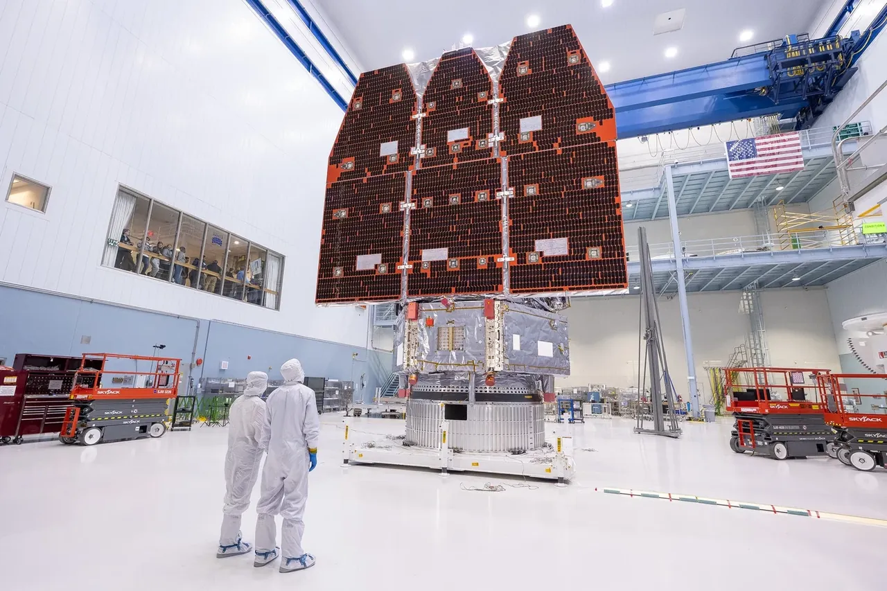 Двое специалистов стоят перед собранным телескопом Roman в чистой комнате NASA.